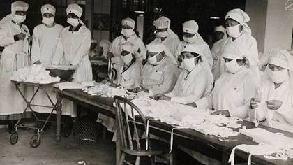 Durante la pandemia de la gripe española, las mascarillas hechas de gasa se usaban ampliamente, pero no ofrecían mucha protección. No obstante, estos trabajadores de la Cruz Roja en Boston ensamblaban mascarillas (National Archives)