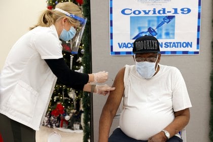 FILE PHOTO: George Valley, a patient at Crown Heights Center for Nursing and Rehabilitation, a nursing home facility, receives the Pfizer-BioNTech coronavirus disease (COVID-19) vaccine from Walgreens Pharmacist Annette Marshall, in Brooklyn, New York, U.S., December 22, 2020. REUTERS/Yuki Iwamura/File Photo