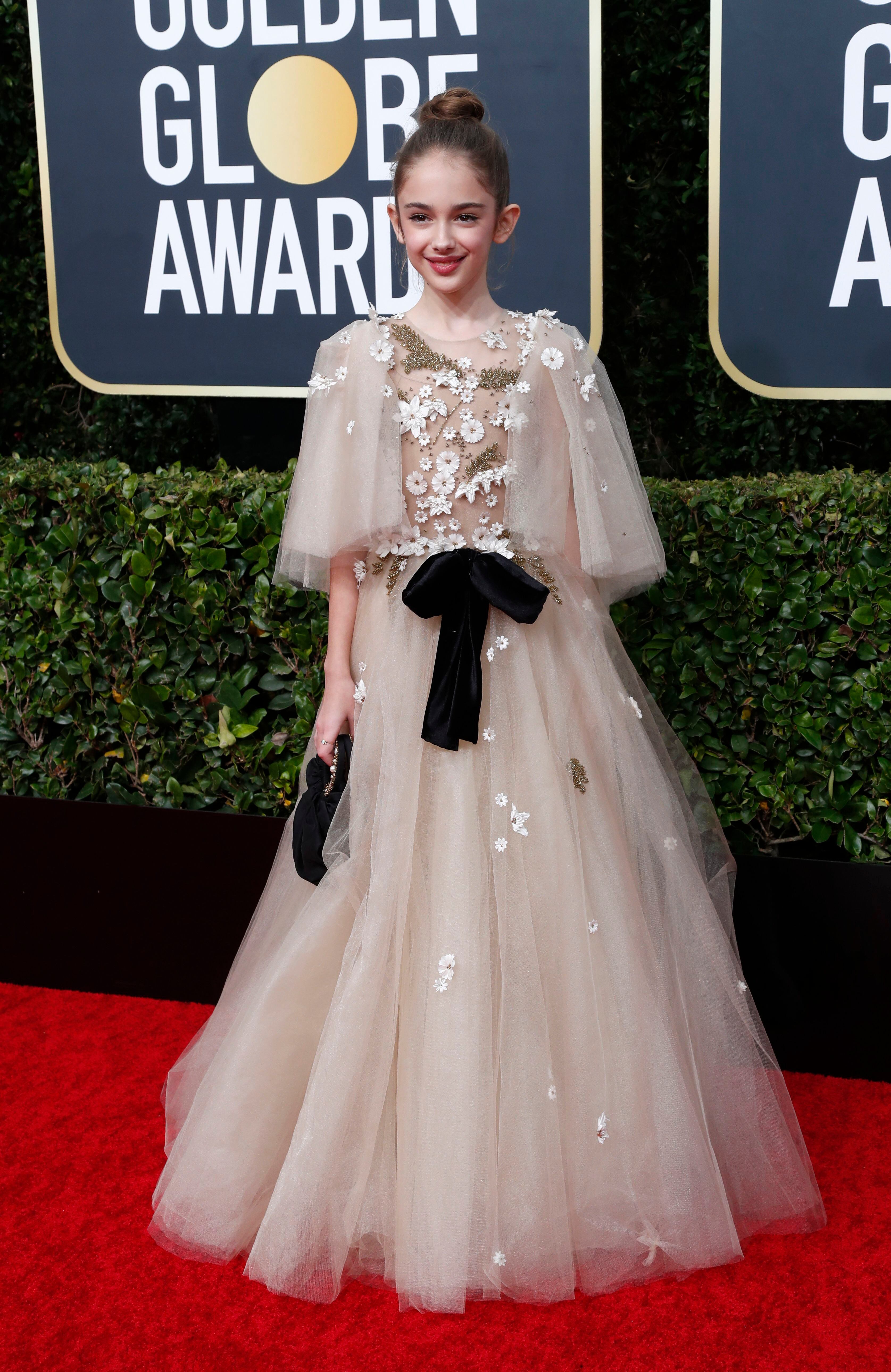 La pequeña actriz Julia Butters, en sus primeros Golden Globes, lució un vestido estilo romántico con detalles de apliques de flores de margaritas y cintas de chiffón 