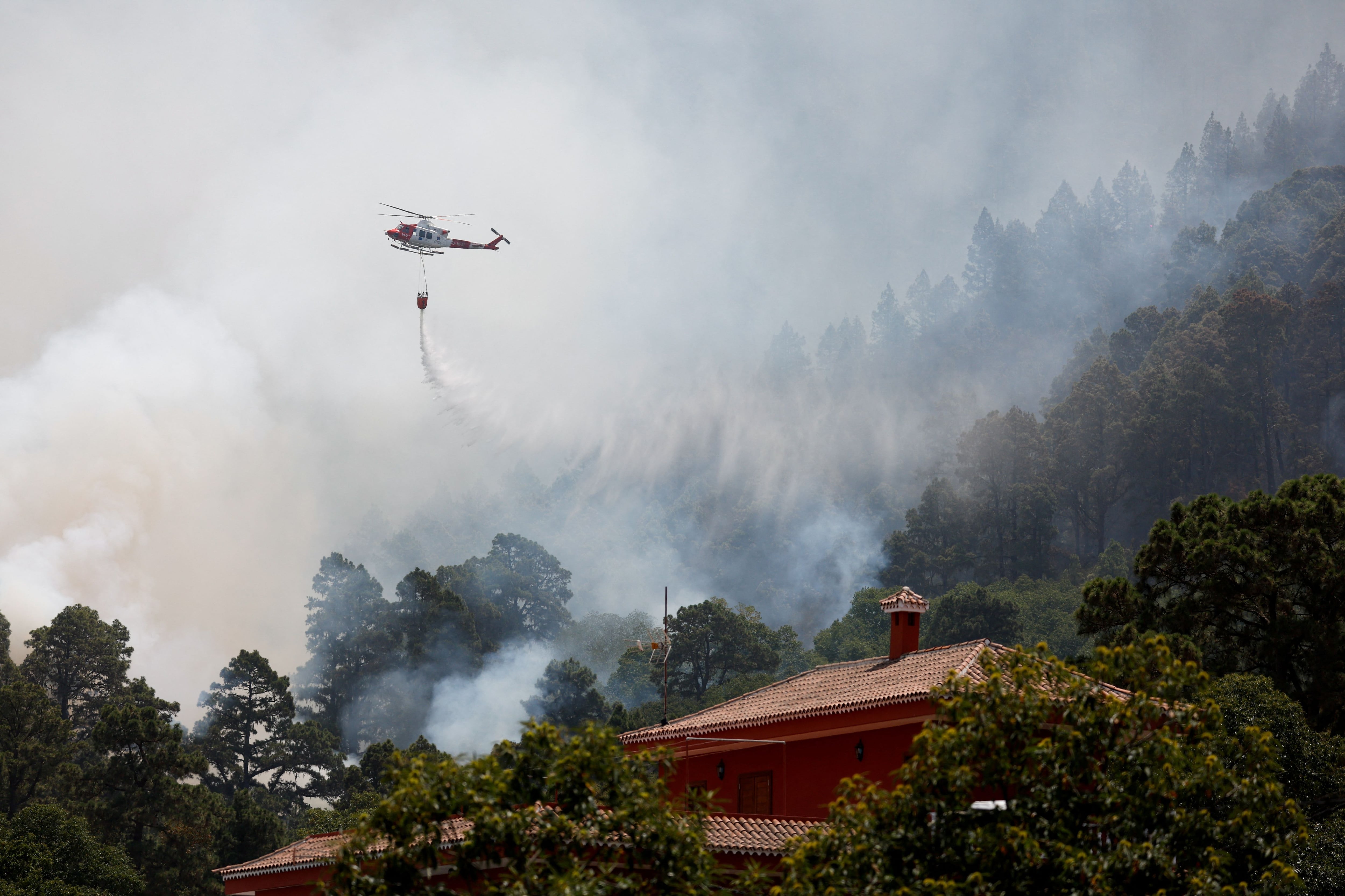 Un helicóptero de extinción de incendios sobrevuela Aguamansa, mientras los incendios forestales se descontrolan en la isla de Tenerife. Borja Suarez/
