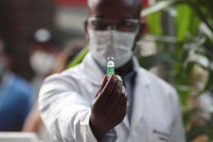 Un trabajador de la salud sostiene un frasco de la vacuna de AstraZeneca 
