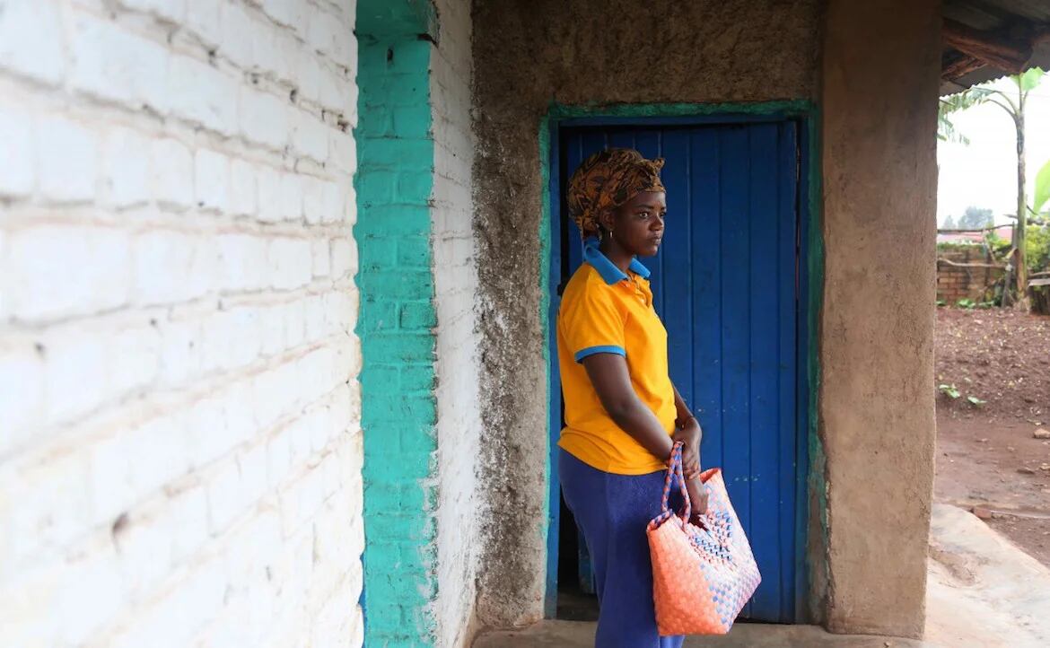 Angel frente a la casa que comparte con su madre, en el sector Ngoma de Ruanda. Sueña con estudiar la carrera de turismo, pero su plan alternativo es vender tomates. (Whitney Shefte)