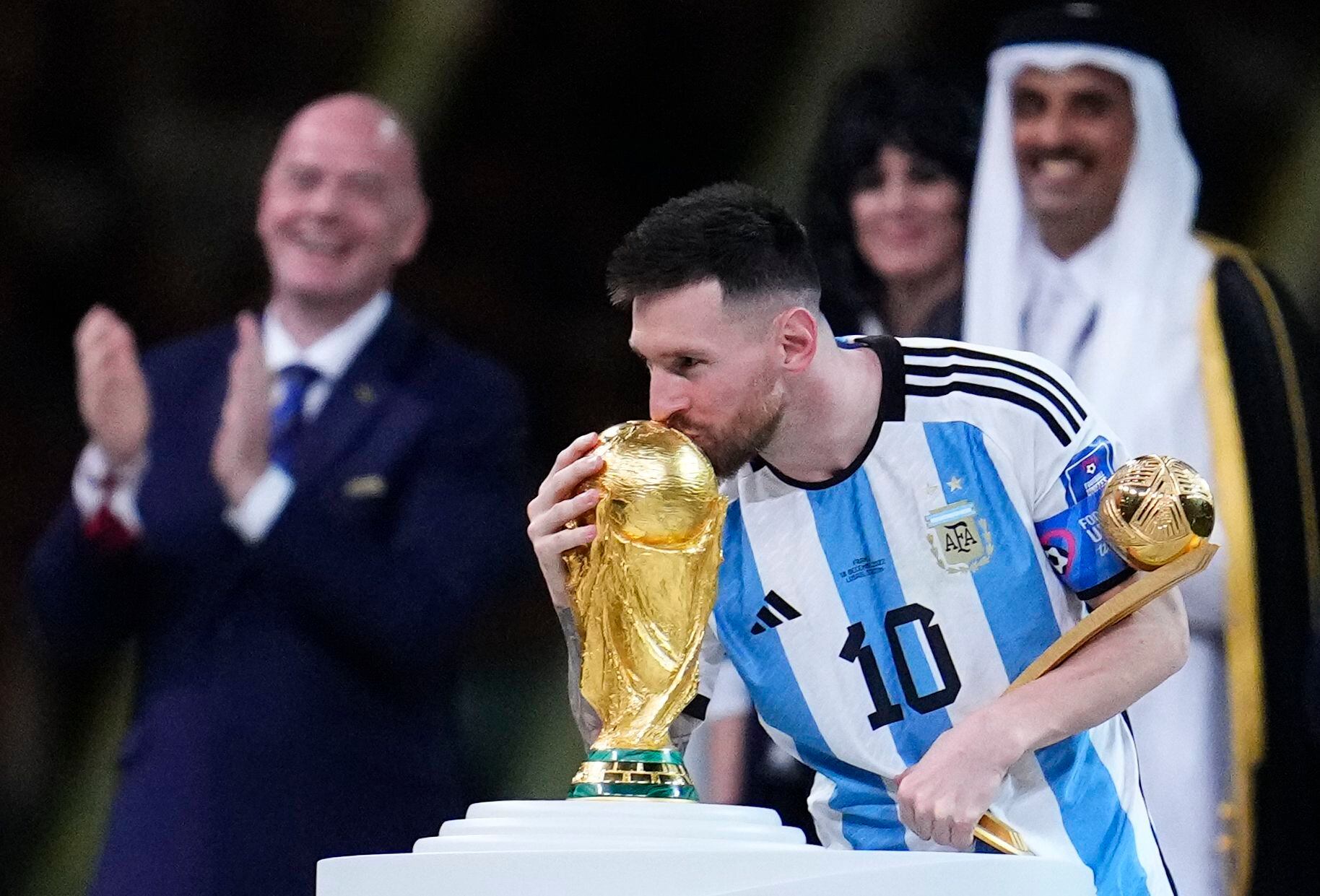 Messi besa la Copa del Mundo durante la entrega de premios en Qatar 2022 (AP Foto/Natacha Pisarenko)