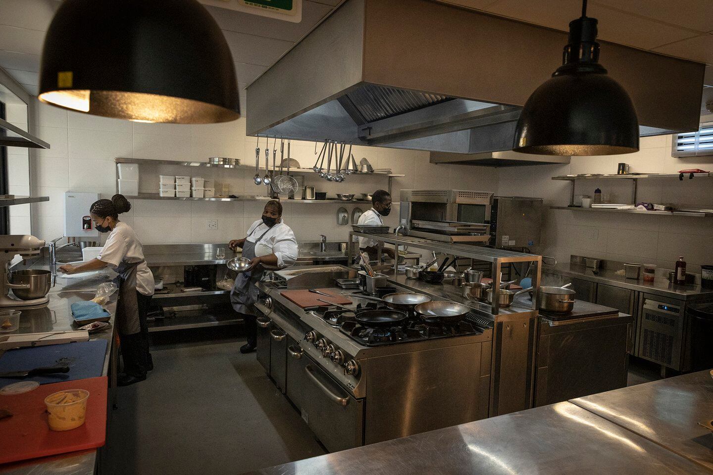 La cocinera personal del ex presidente sudafricano Nelson Mandela y ahora chef del restaurante Sanctuary Mandela, Xoliswa Ndoyiya, prepara los alimentos en la cocina del restaurante en Johannesburgo, el 19 de noviembre de 2021 (Foto de GUILLEM SARTORIO / AFP)