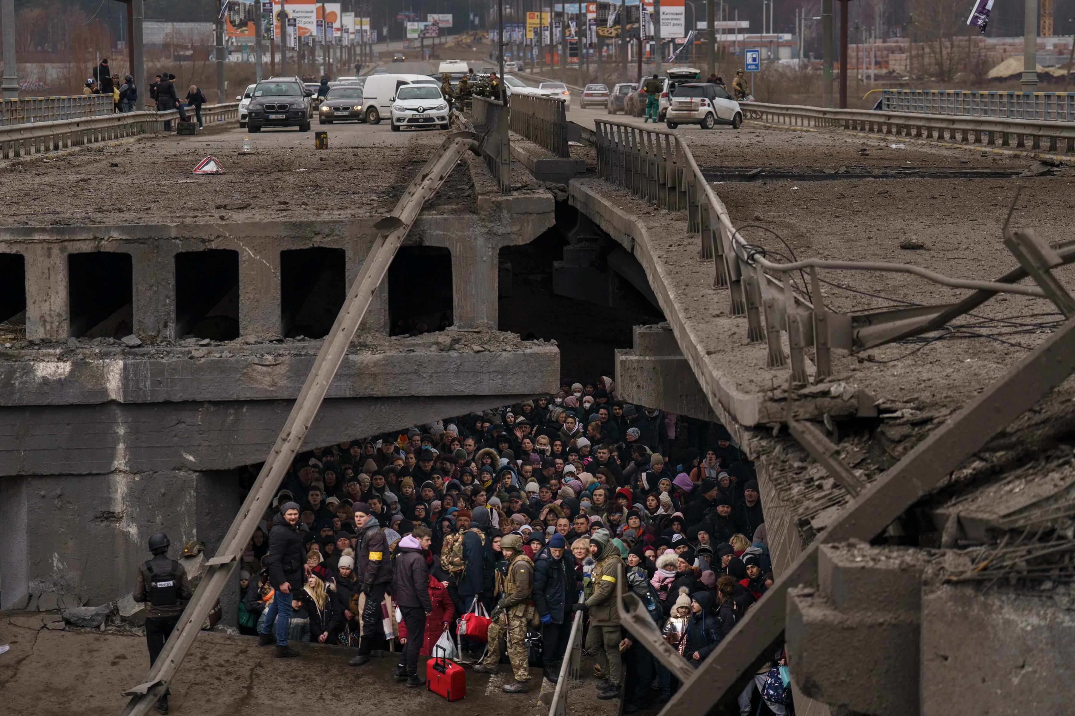 Ucranianos se agolpan bajo un puente destruido mientras intentan huir cruzando el río Irpin en las afueras de Kiev, Ucrania, el sábado 5 de marzo de 2022.