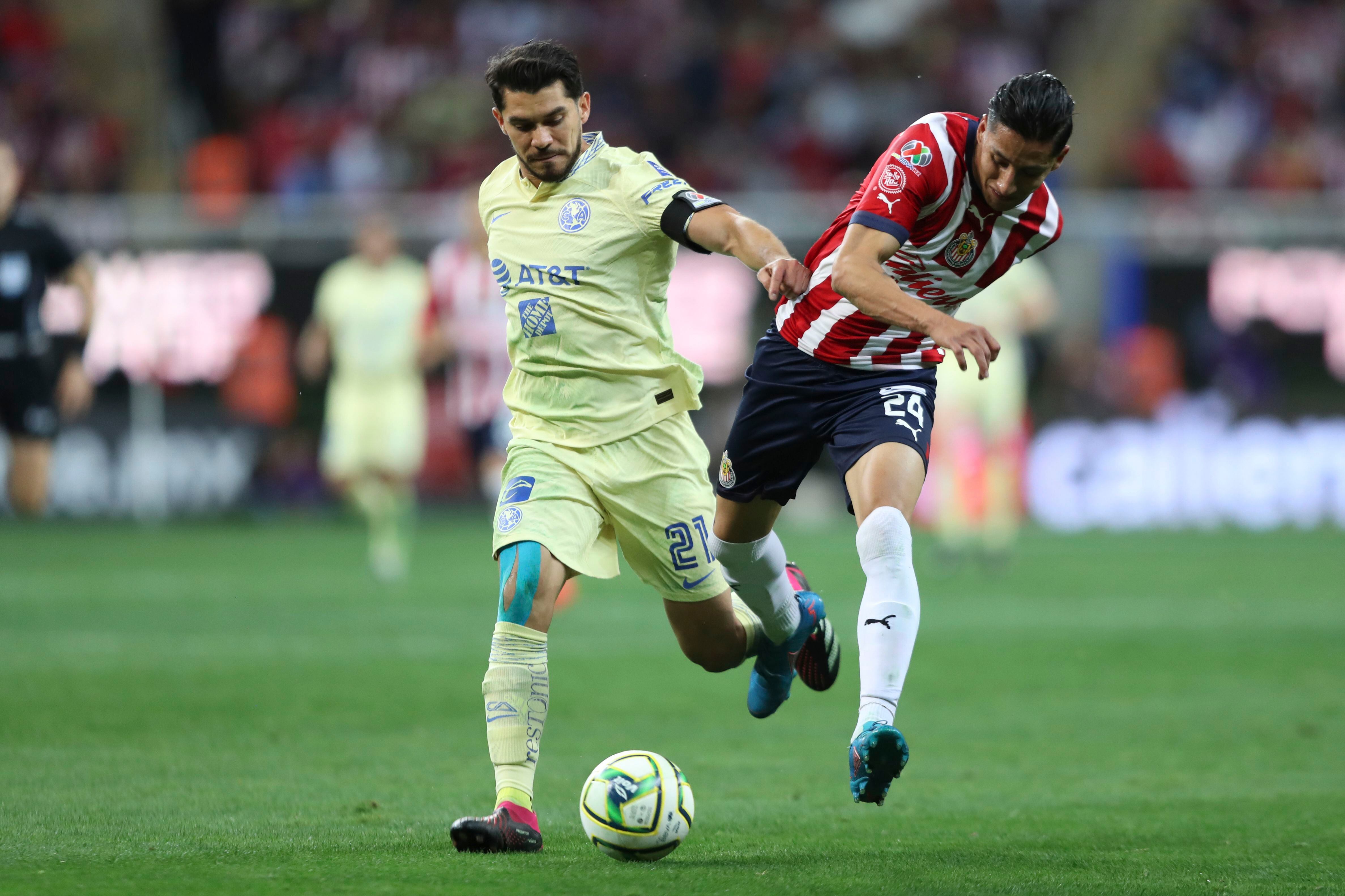 El jugador del América Henry Martín, a la izquierda, y el jugador del Chivas Carlos Cisneros luchan por el balón en un juego del torneo Clausura mexicano en el estadio Akron de Guadalajara, México, el sábado 18 de marzo de 2023. (AP Foto)