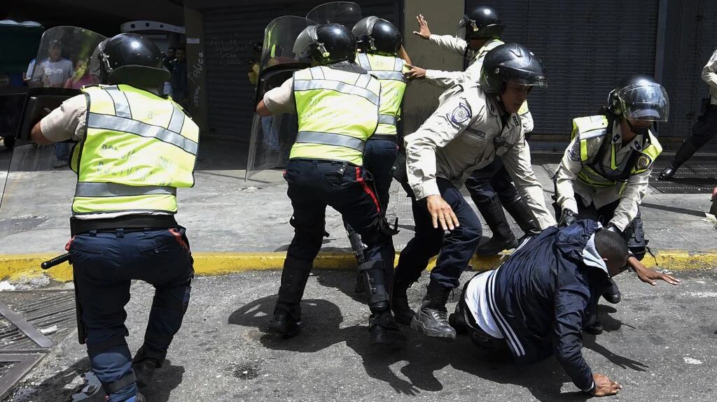 Fuerzas de seguridad de Venezuela golpean y arrestan a un hombre que protestaba contra el desabastecimiento (AFP)