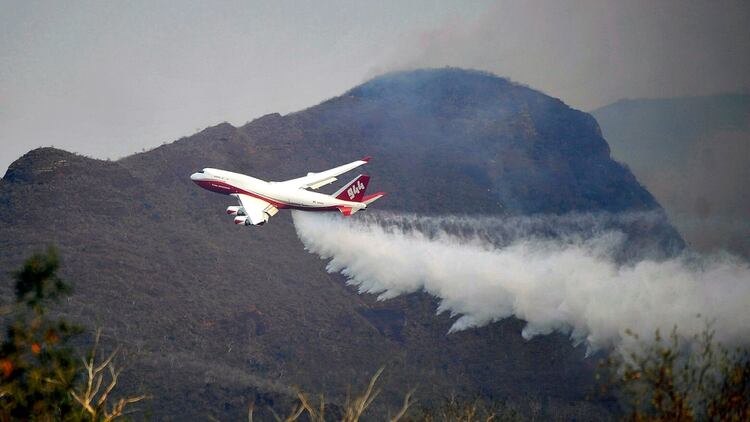 Un avión intenta apagar algunos de los incendios (Foto: AFP)