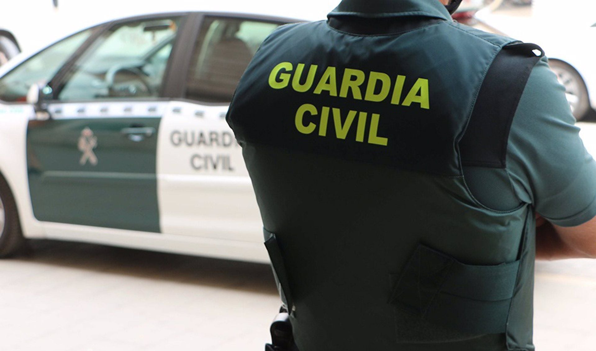 Un agente de la Guardia Civil, de espaldas, junto a un vehículo oficial (Europa Press) 