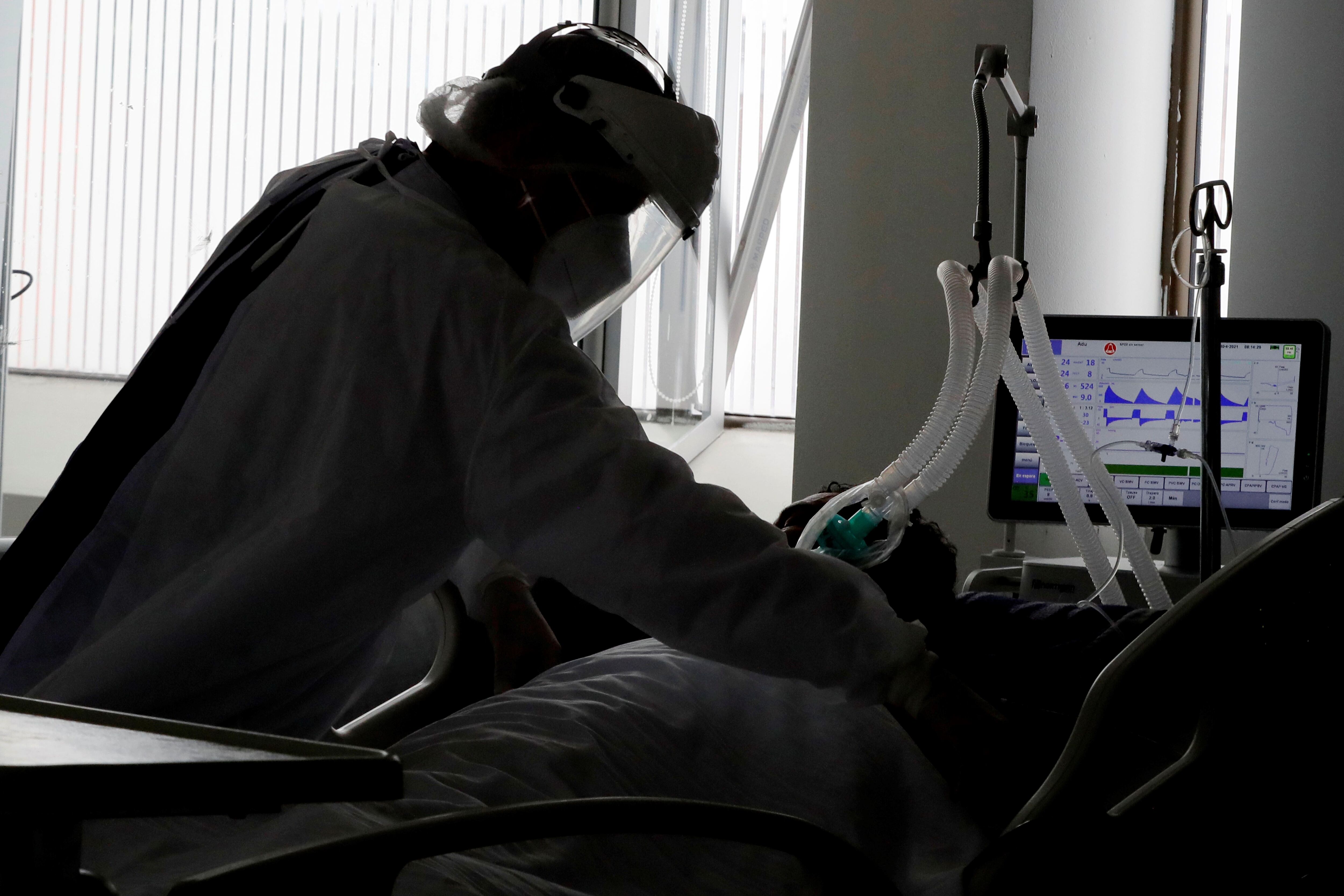 Una empleada de la salud atiende a un paciente en una unidad de cuidados intensivos para enfermos de covid-19 en Bogotá (Colombia), en una fotografía de archivo. EFE/Carlos Ortega