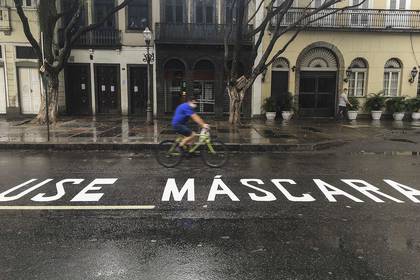 -FOTODELDIA- BRA02. RÍO DE JANEIRO (BRASIL), 03/05/2020.- Un hombre monta bicicleta junto a un mensaje que dice "Use Máscara" pintada en la calle, este domingo durante la pandemia de COVID-19, en Río de Janeiro (Brasil). EFE/Antonio Lacerda
