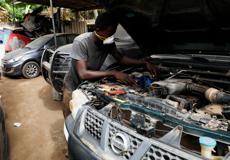 Un mecánico trabaja con el barbijo puesto en su boca en un taller de Accra, capital de Ghana (REUTERS/Francis Kokoroko)