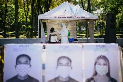 Un trabajador de la salud con equipo de protección personal (EPP) toma una muestra con un hisopo de una persona para detectar el COVID-19 en Ciudad de México. 15 de octubre de 2020. REUTERS/Edgard Garrido