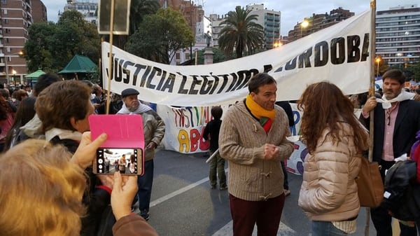 Senestrari con una bandera de Justicia Legítima Córdoba, en una movilización reciente contra las demoras en la causa por la financiera CBI