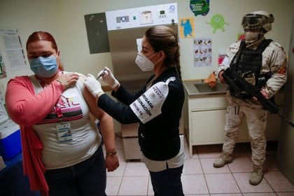 Un trabajador de la salud recibe una inyección con una dosis de la vacuna de Pfizer-BioNTech contra el COVID-19 en el Hospital Infantil, mientras continúa la propagación del coronavirus, en Ciudad Juárez, México. 14 de enero de 2021. REUTERS / José Luis González