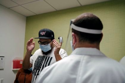 Gilbert Torres, left, returns to Martin Luther King Jr. Community Hospital in Los Angeles, where he had been on a ventilator in the intensive care unit, on Feb. 9, 2021. The hospital has created a new outpatient clinic for COVID-19 survivors, intended to address their lingering physical and psychic wounds — and to help keep them from needing to be readmitted. (Isadora Kosofsky/The New York Times)