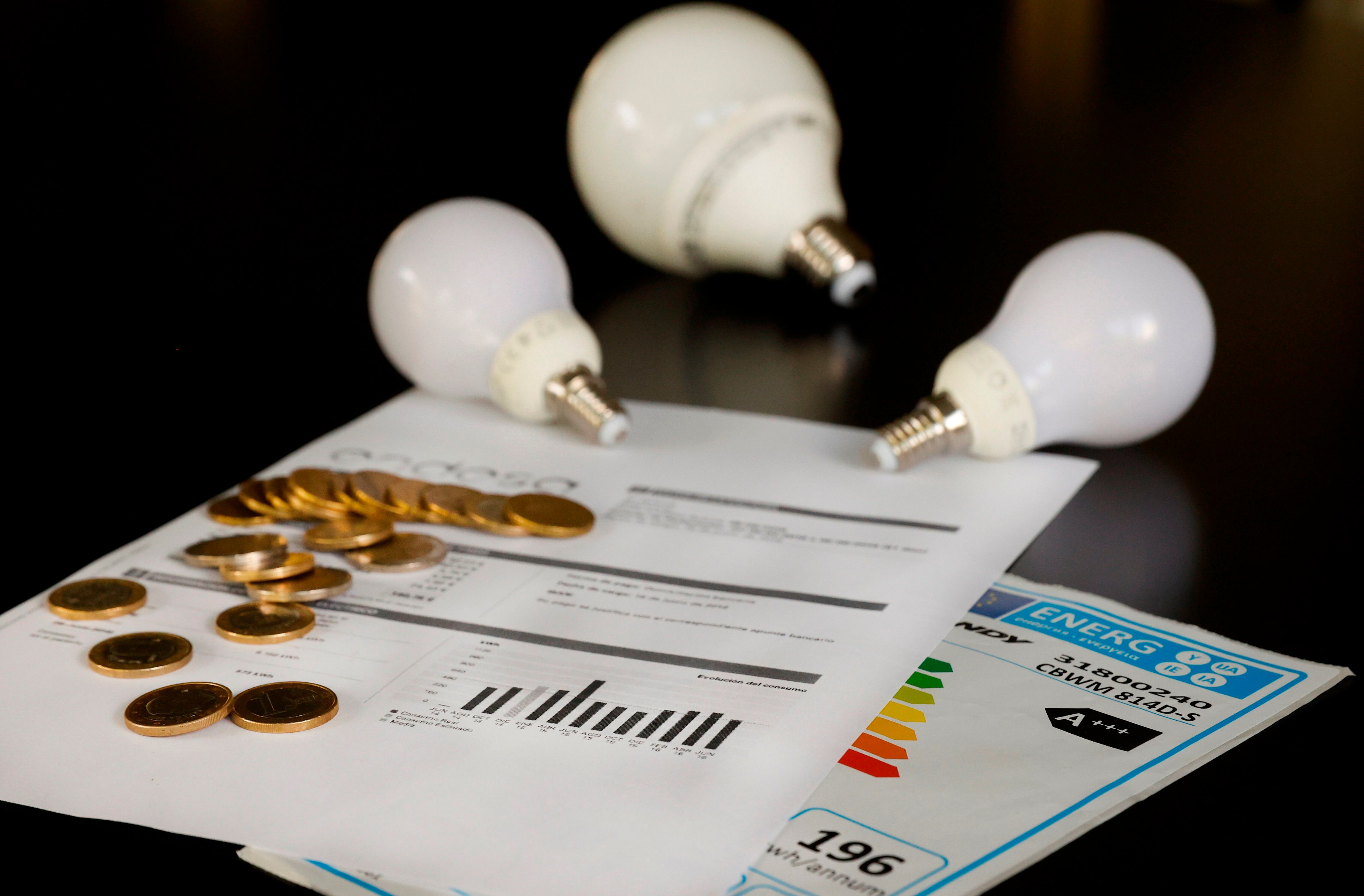 Varias bombillas sobre una factura de la luz, en una fotografía de archivo. EFE/JUAN CARLOS HIDALGO 