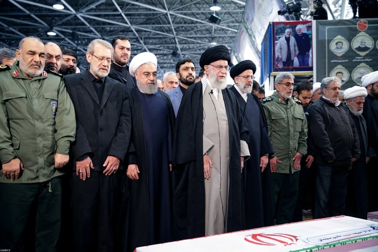 El líder supremo iraní Alí Khamenei, en el centro de la imagen, reza ante los restos de Soleimani acompañado por el presidente Hassan Rohani (Web Oficial del presidente/Handout via REUTERS)