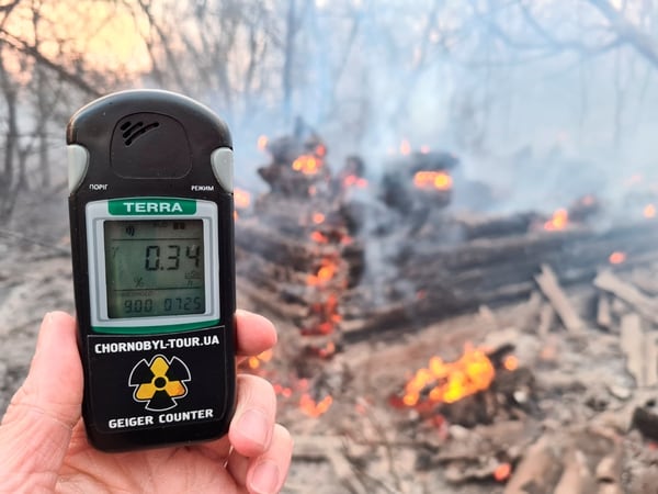 Un contador geiger mide el nivel de radiación en un sitio de incendio en la zona de exclusión alrededor de la central nuclear de Chernobyl, en las afueras de la aldea de Rahivka, Ucrania, 5 de abril de 2020. Fotografía tomada el 5 de abril de 2020. (REUTERS / Yaroslav Yemelianenko)