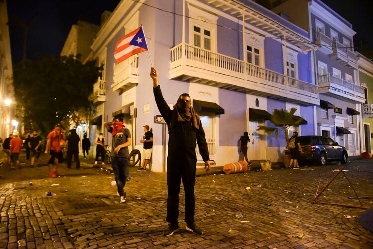 Un manifestante sostiene una bandera de Puerto Rico para exigir la renuncia de Rosselló (AP Photo/Carlos Giusti)