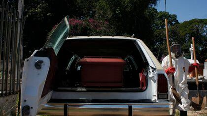 Trabajadores gubernamentales se disponen a bajar un ataúd con una víctima de covid-19 de un vehículo para proceder a enterrarlo, el 19 de septiembre, en San Cristóbal (Venezuela). EFE/ Johnny Parra/Archivo
