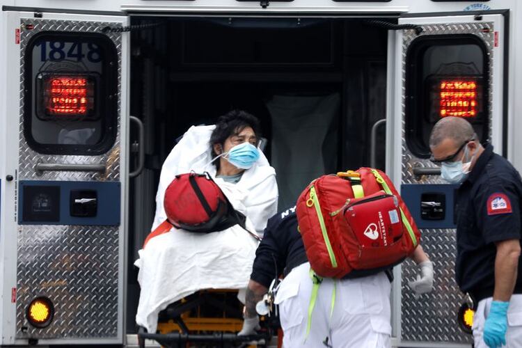 Una mujer es subida a una ambulancia por paramédicos en el vecindario de Harlem en Manhattan durante el brote de COVID-19, la enfermedad causada por el coronavirus, en la Ciudad de Nueva York, Nueva York, Estados Unidos. 8 de abril, 2020. REUTERS/Mike Segar