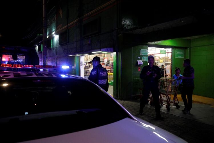 Policías resguardan una tienda de autoservicio para evitar saqueos en Ciudad de México. (Foto: Luis Cortés/Reuters)