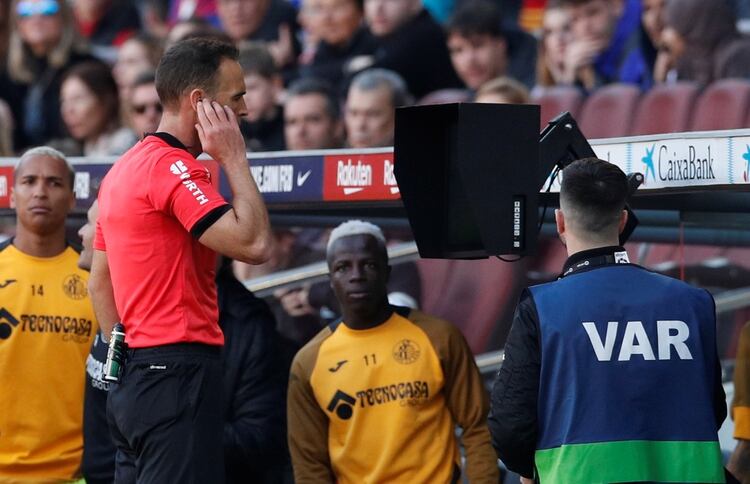 Soccer Football - La Liga Santander - FC Barcelona v Getafe - Camp Nou, Barcelona, Spain - February 15, 2020 Referee Guillermo Cuadra Fernandez checks the pitchside VAR monitor before disallowing a goal scored by Getafe's Allan Nyom REUTERS/Albert Gea