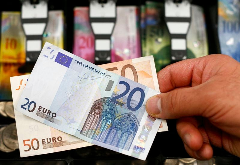 Un billete de 20 y 50 euros ante una caja registradora con francos suizos en Berna. (Reuters/Thomas Hodel)