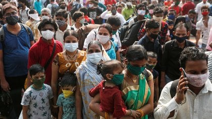 People wearing protective masks stand outside a railway station amidst the spread of the coronavirus disease (COVID-19), in Mumbai, India, April 13, 2021. REUTERS/Francis Mascarenhas