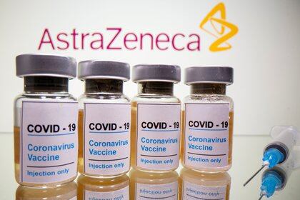 FILE PHOTO: FILE PHOTO: Vials with a sticker reading, "COVID-19 / Coronavirus vaccine / Injection only" and a medical syringe are seen in front of a displayed AstraZeneca logo in this illustration taken October 31, 2020. REUTERS/Dado Ruvic/Illustration/File Photo/File Photo