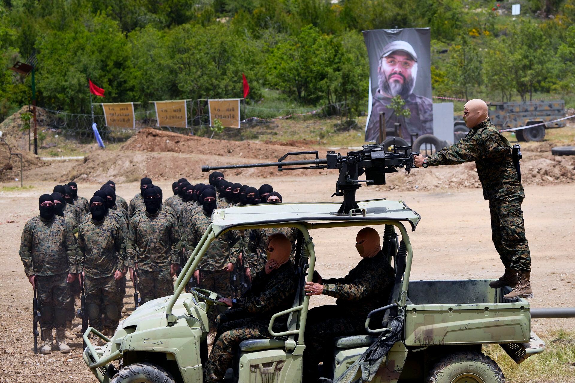 Combatientes de Hezbollah durante un entrenamiento en la aldea de Aaramta, Líbano, en mayo de 2023. El cartel de fondo muestra una foto de Imad Mughniyeh. (AP Photo/Hassan Ammar)