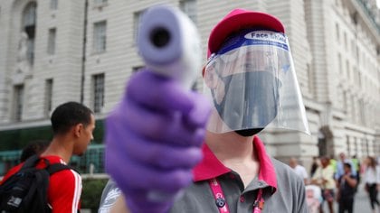 Un empleado realiza un chequeo de temperatura en el recién reabierto London Eye, en medio del brote de la enfermedad coronavirus (COVID-19), en Londres, Gran Bretaña, el 1 de agosto de 2020. REUTERS/Peter Cziborra