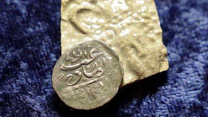 Una moneda de plata árabe del siglo XVII, en la parte superior, que según las investigaciones se acuñó en 1693 en Yemen (AP)