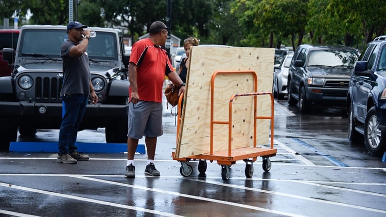 Los trabajadores de Home Depot ayudan a los residentes en Miami que están comprando madera contrachapada y otros suministros el 29 de agosto de 2019 ante la llegada del huracán Dorian (AFP)