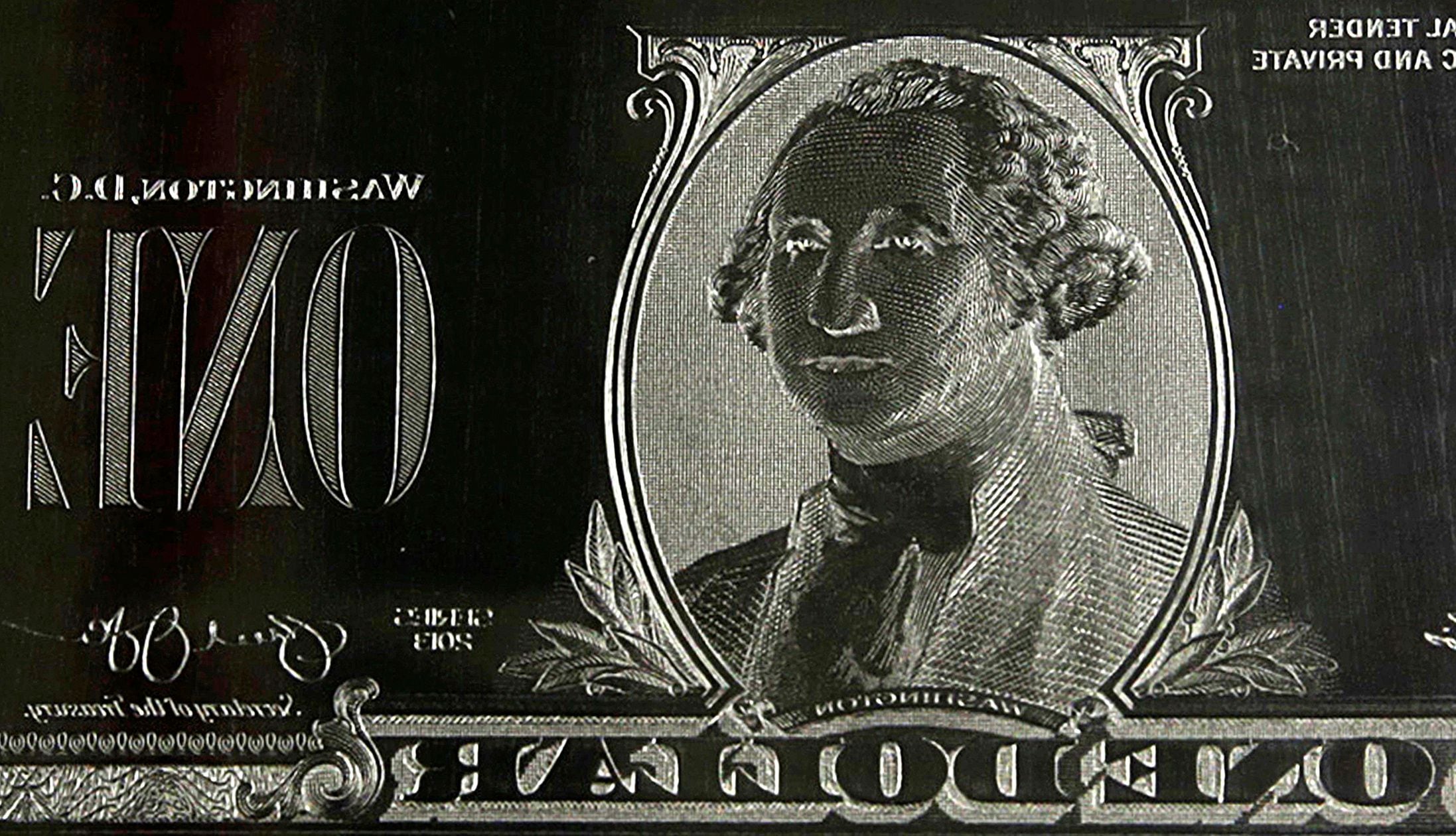 FILE PHOTO: The image of United States President George Washington is seen on an engraving plate for a US one dollar bill at the Bureau of Engraving and Printing in Washington November 14, 2014. The plate goes on the printing press which prints the currency./File Photo