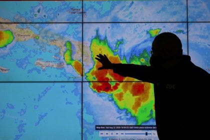 Un miembro del Comité de Operaciones de Emergencia mira la trayectoria de la tormenta Laura en Santo Domingo, República Dominicana (REUTERS/Ricardo Rojas)
