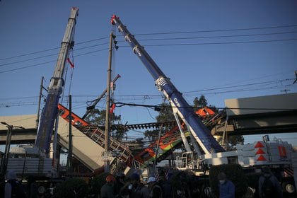 Grúas trabajan en un sitio donde un paso elevado de un metro colapsó parcialmente con vagones de tren en la estación de Olivos en la Ciudad de México, México, 4 de mayo de 2021. REUTERS / Henry Romero
