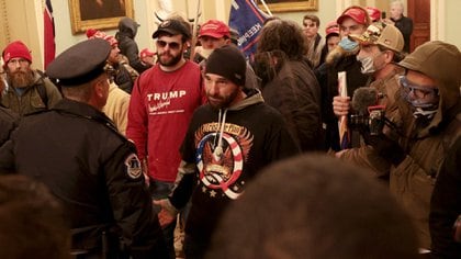 Los manifestantes interactúan con la policía del Capitolio dentro del edificio del Capitolio de los EE.UU. el 06 de enero de 2021 en Washington, DC (Win McNamee/Getty Images/AFP)