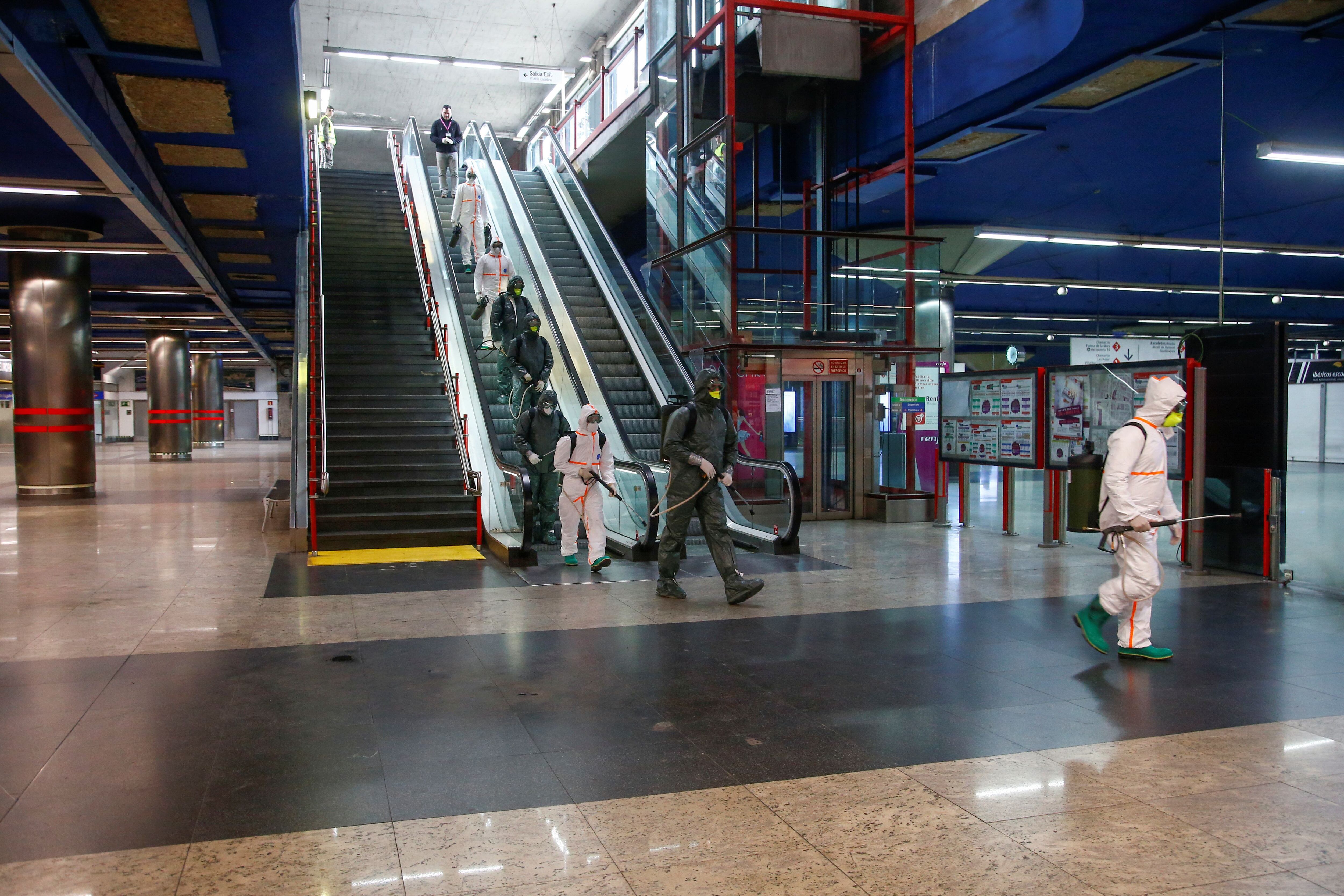 Fuerzas militares de emergencia desinfectan la estación de metro Nuevos ministerios en la capital española. 