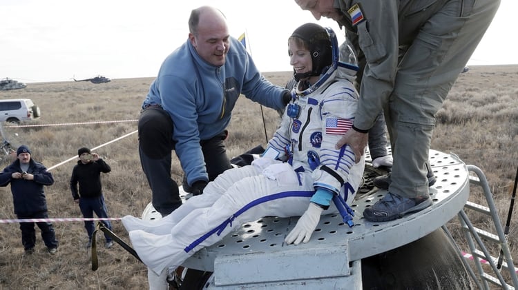El personal de tierra ayuda a la astronauta estadounidense Kate Rubins, miembro de la tripulación de la Estación Espacial Internacional (ISS), a salir de la cápsula espacial Soyuz MS después de aterrizar a unos 150 km ( al sudeste de la ciudad de Dzhezkazgan, Kazajstán, el 30 de octubre de 2016. (AFP)