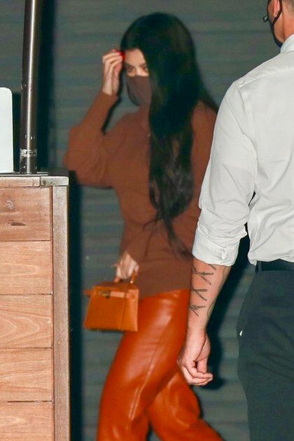Kourtney Kardashian fue a comer con su hijo, Mason, al exclusivo restaurante Nobu en Malibú. Buscó pasar desapercibida y evitar a los paparazzis. Lució un look total marrón: pantalón y cartera de cuero, zapatos y sweater. Combinó su outfit con un tapabocas del mismo color