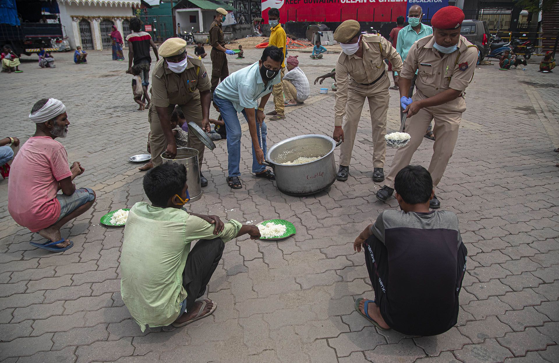 La policía distribuye alimentos gratuitos a las personas sin hogar durante el cierre nacional en Gauhati, India, el jueves 23 de abril de 2020 (AP Photo/Anupam Nath)