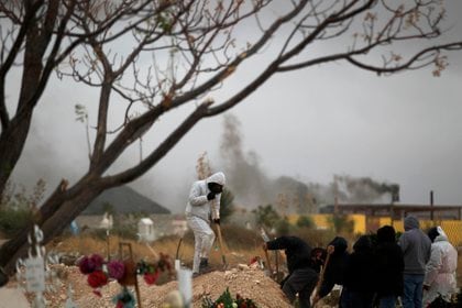 Empleados funerarios sepultan a personas fallecidas por la covid-19 este martes, en el cementerio San Rafael en la fronteriza Ciudad Ju&#225;rez, estado de Chihuahua. EFE/Luis Torres

