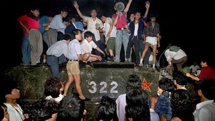 Un grupo de jóvenes sobre un tanque cerca de la Plaza Tiananmén