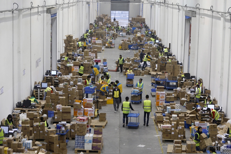 Empleados de una empresa de logística en Wuhan separan paquetes durante un festival de comercio electrónico (Reuters)
