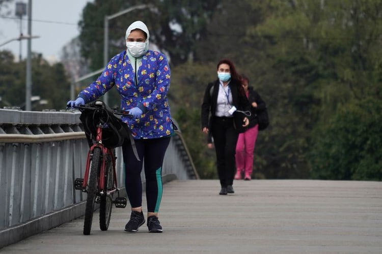 Personas usando tapabocas durante el aislamiento preventivo obligatorio decretado por el gobierno para frenar la expansión del coronavirus caminan sobre un puente peatonal en Bogotá, Colombia, 20 de marzo, 2020. REUTERS/Nathalia Angarita.
