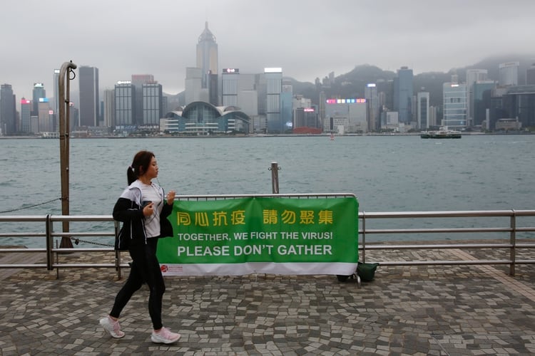 Una mujer pasa junto a una pancarta de consejos de salud en la atracción turística Tsim Sha Tsui, después del brote de la nueva enfermedad por coronavirus en Hong Kong (Reuters)