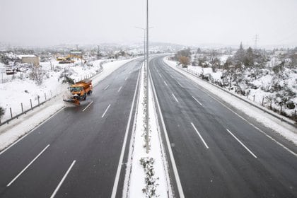 Un vehículo remueve la nieve acumulada a la vera de una autopista vacía en Krioneri (REUTERS/Alkis Konstantinidis)