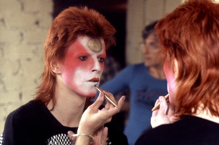 Bowie pintándose con la técnica del teatro kabuki antes de salir a escena, en 1973. (R Bamber/Shutterstock)